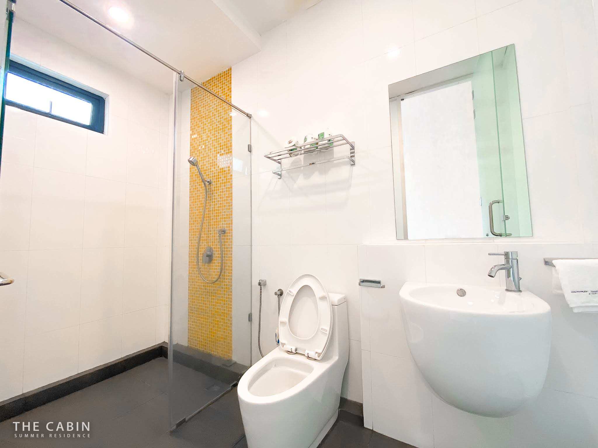 Room 3 ensuite with a yellow and orange mosaic accent stripe in the glass shower.