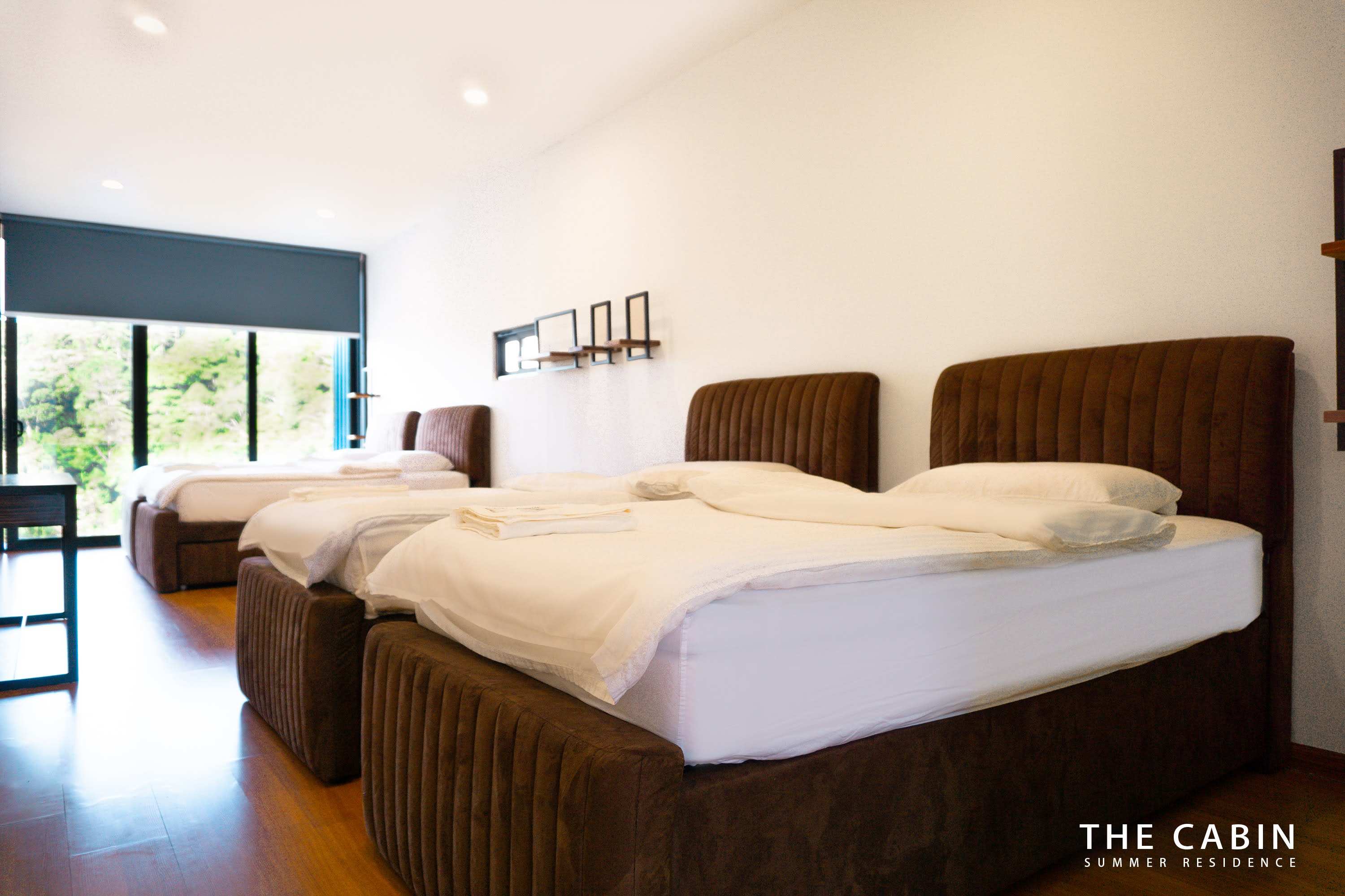 Room 4 in its twin layout: two beds side by side with matching headboards, mountain window at the far end.