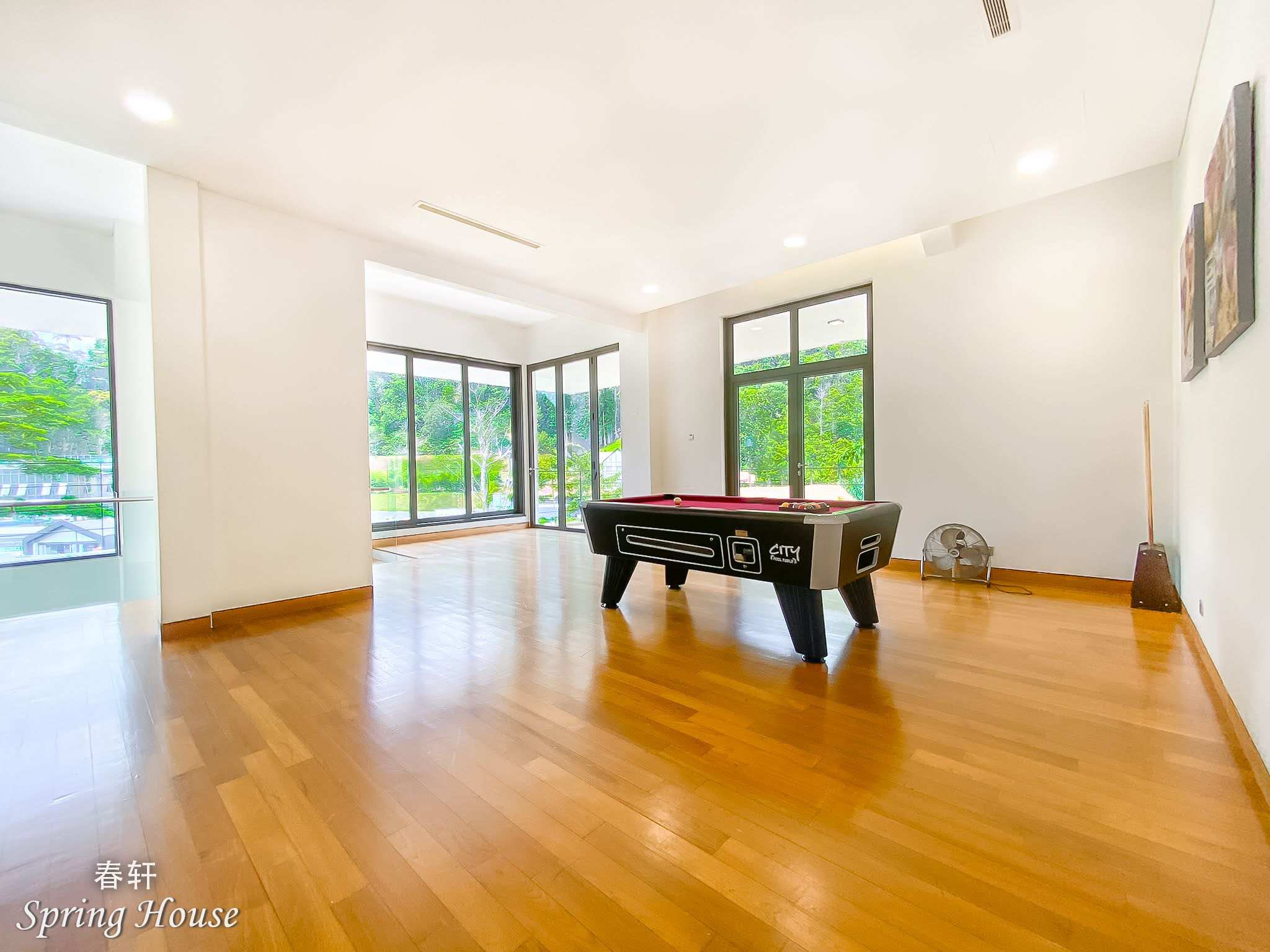 The top-floor games room from the opposite corner, wall art and balcony doors behind the pool table.