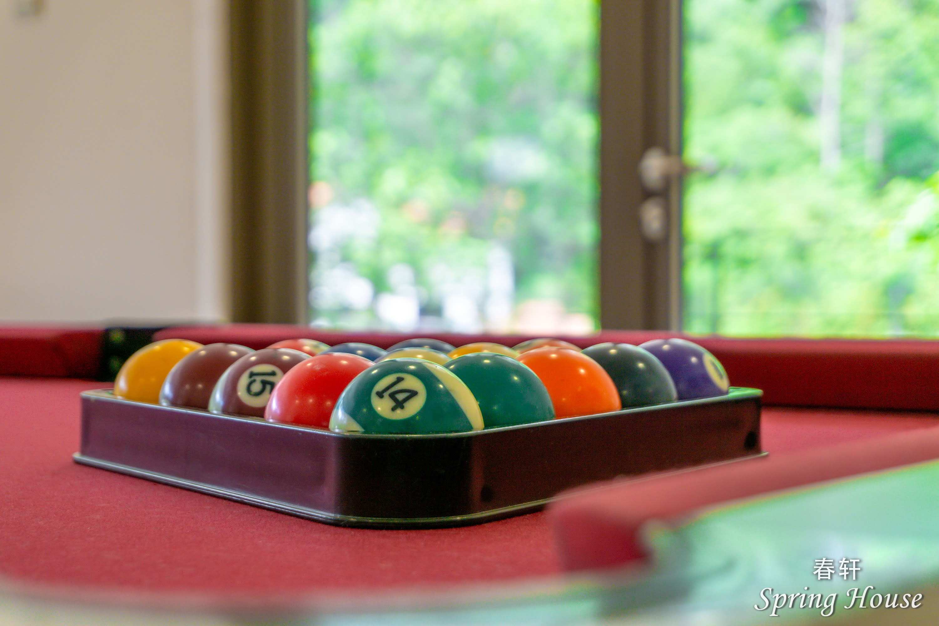 Close-up of racked pool balls on the red felt.