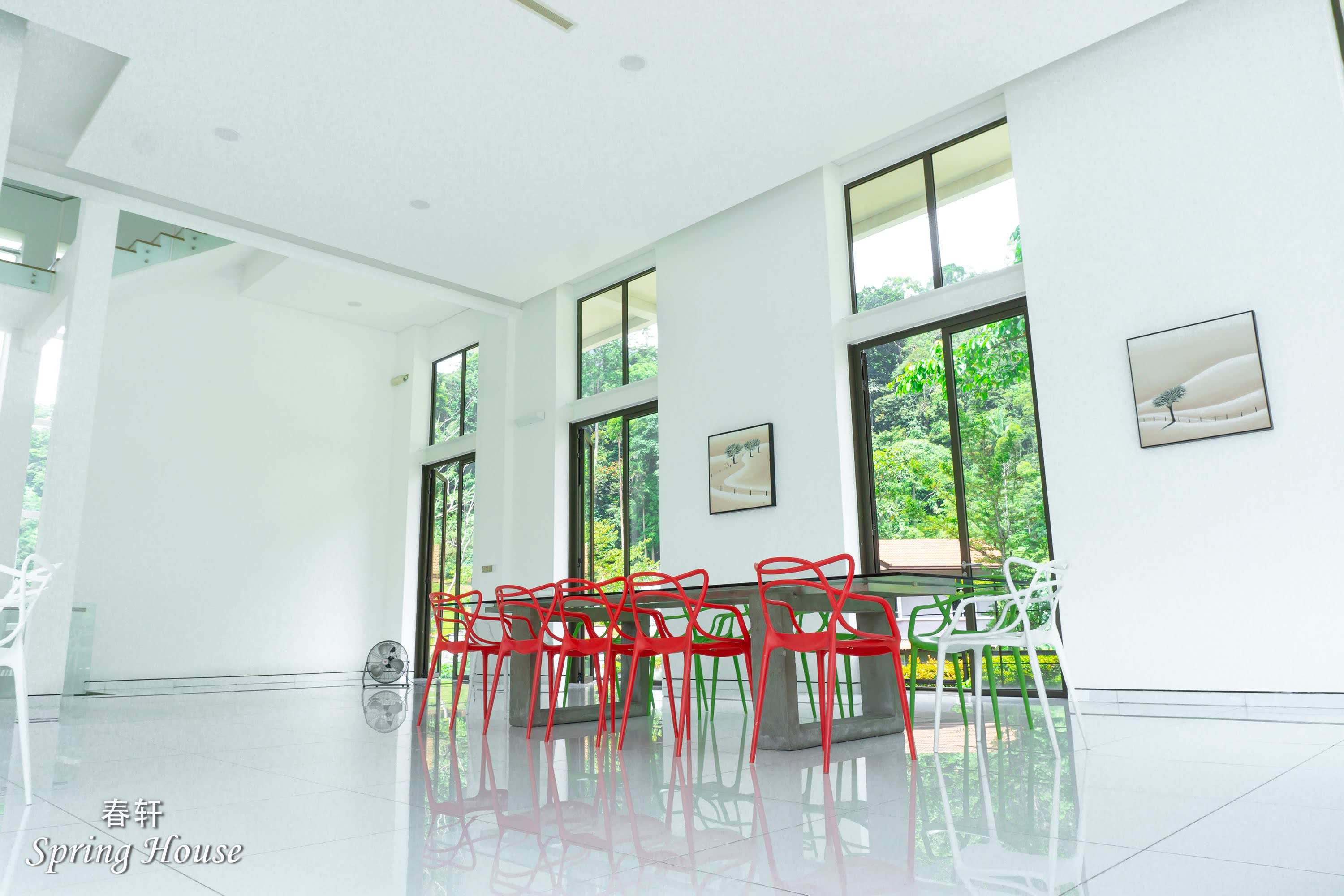 The double-height dining nook seen from above, tall windows framing the mountain view.