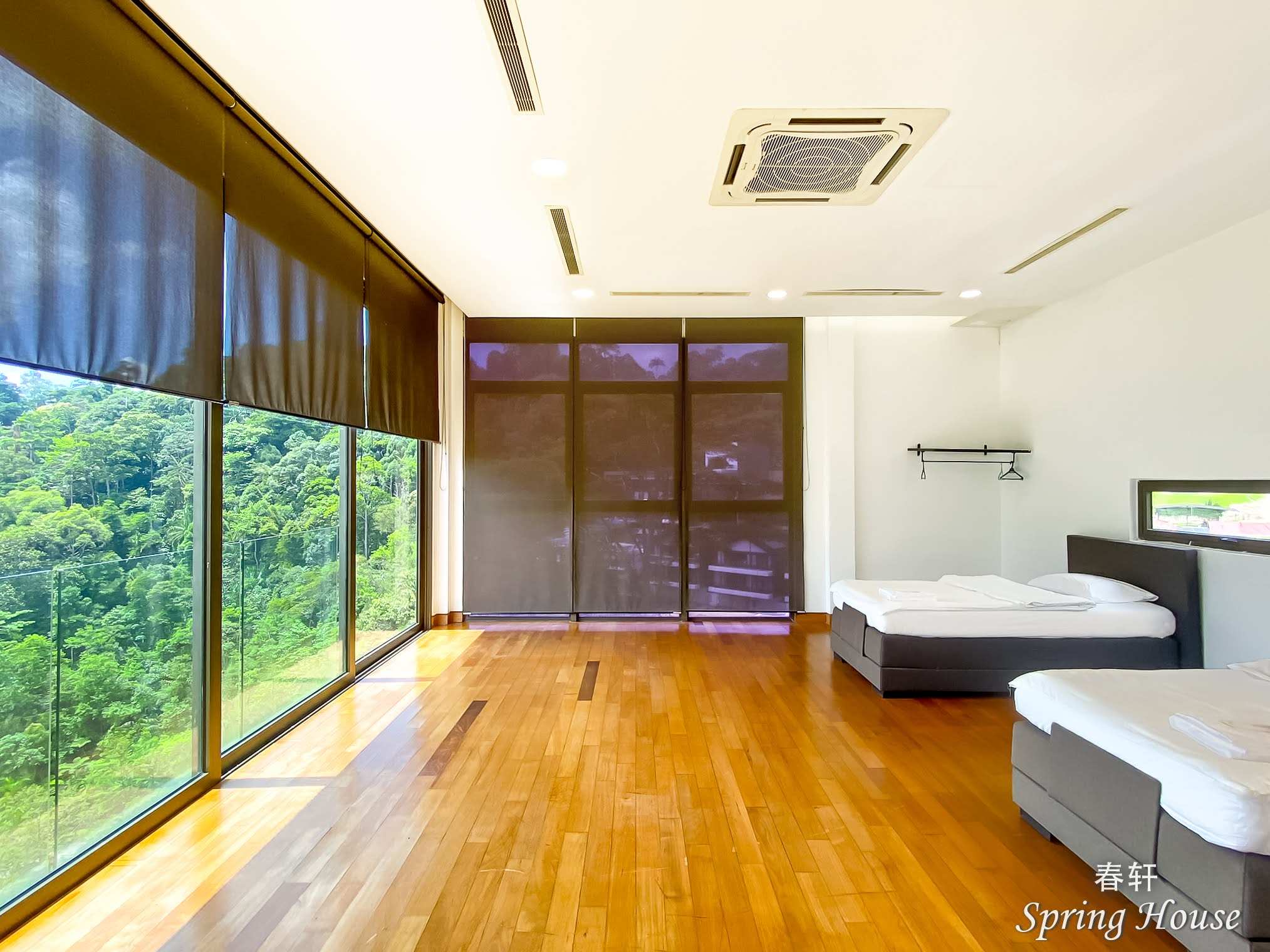 Upper-floor corridor with floor-to-ceiling windows along one side and the staircase down.
