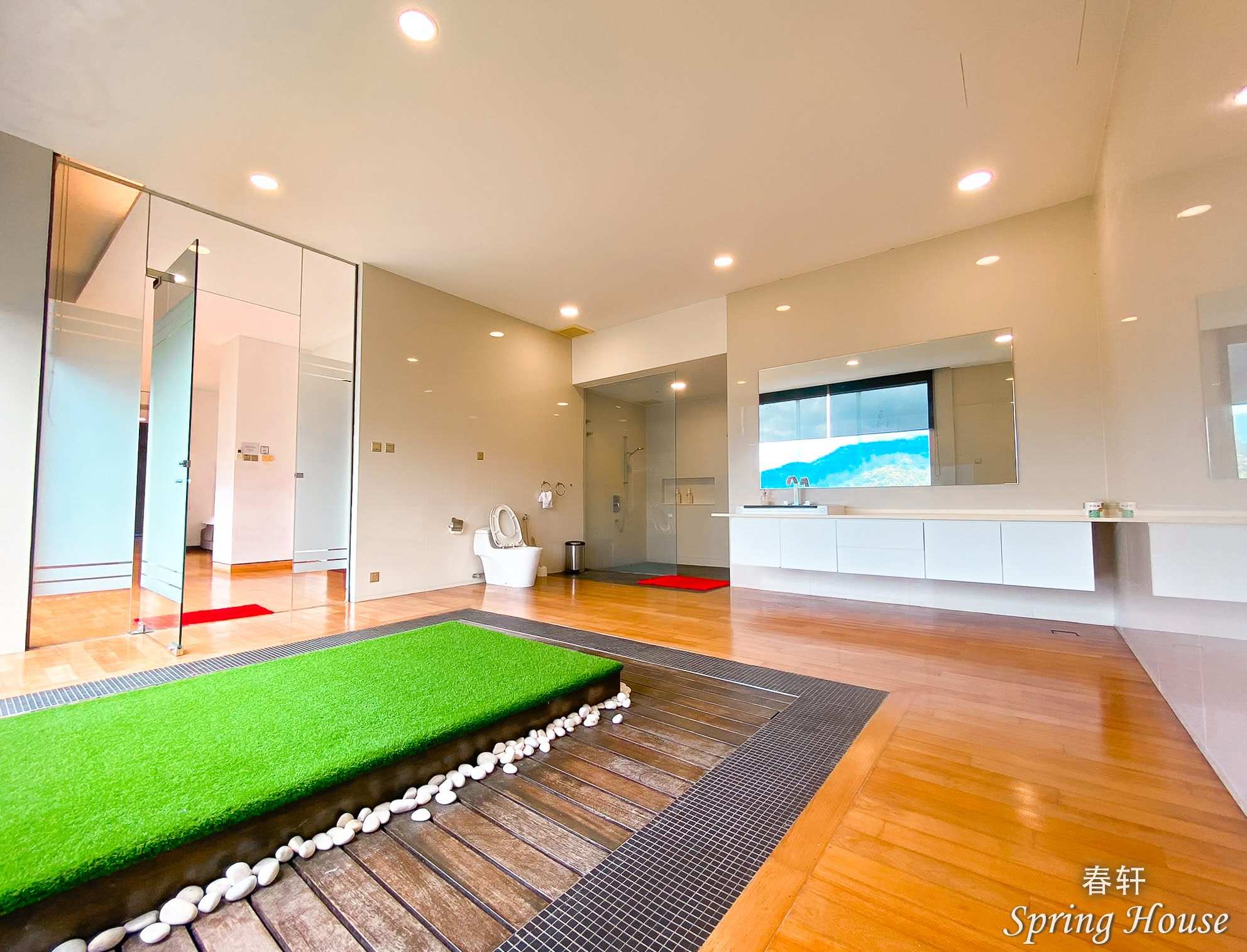 Twin room with dark grey bed frames, a large window and a wall-mounted TV bracket.
