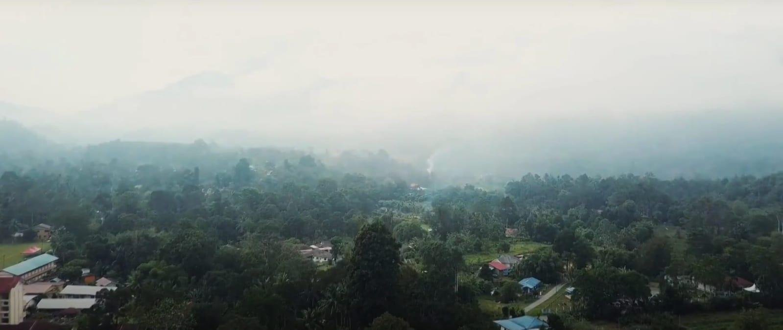 Mist over the forested Janda Baik valley with kampung houses among the trees