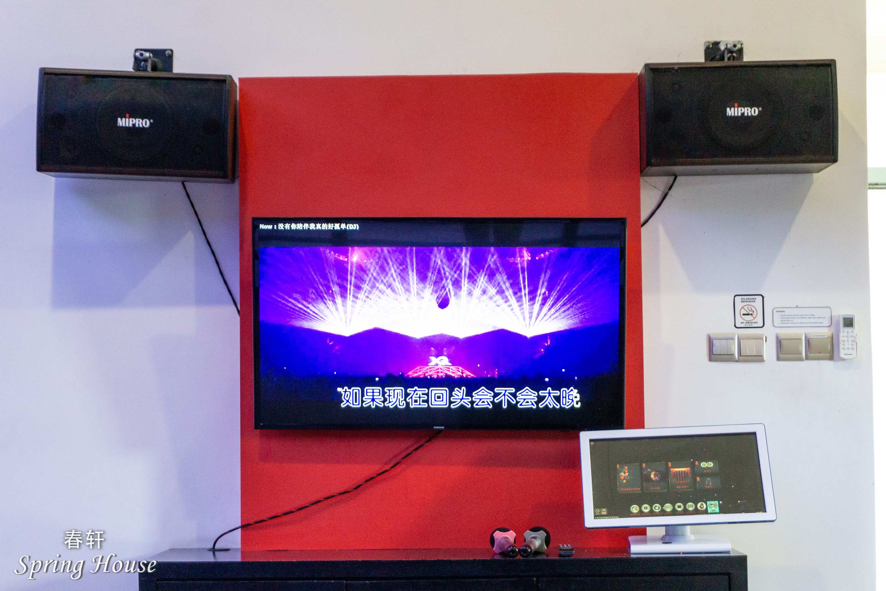 The karaoke setup close up: screen with lyrics, two MIPRO speakers and a touchscreen song-selection tablet.