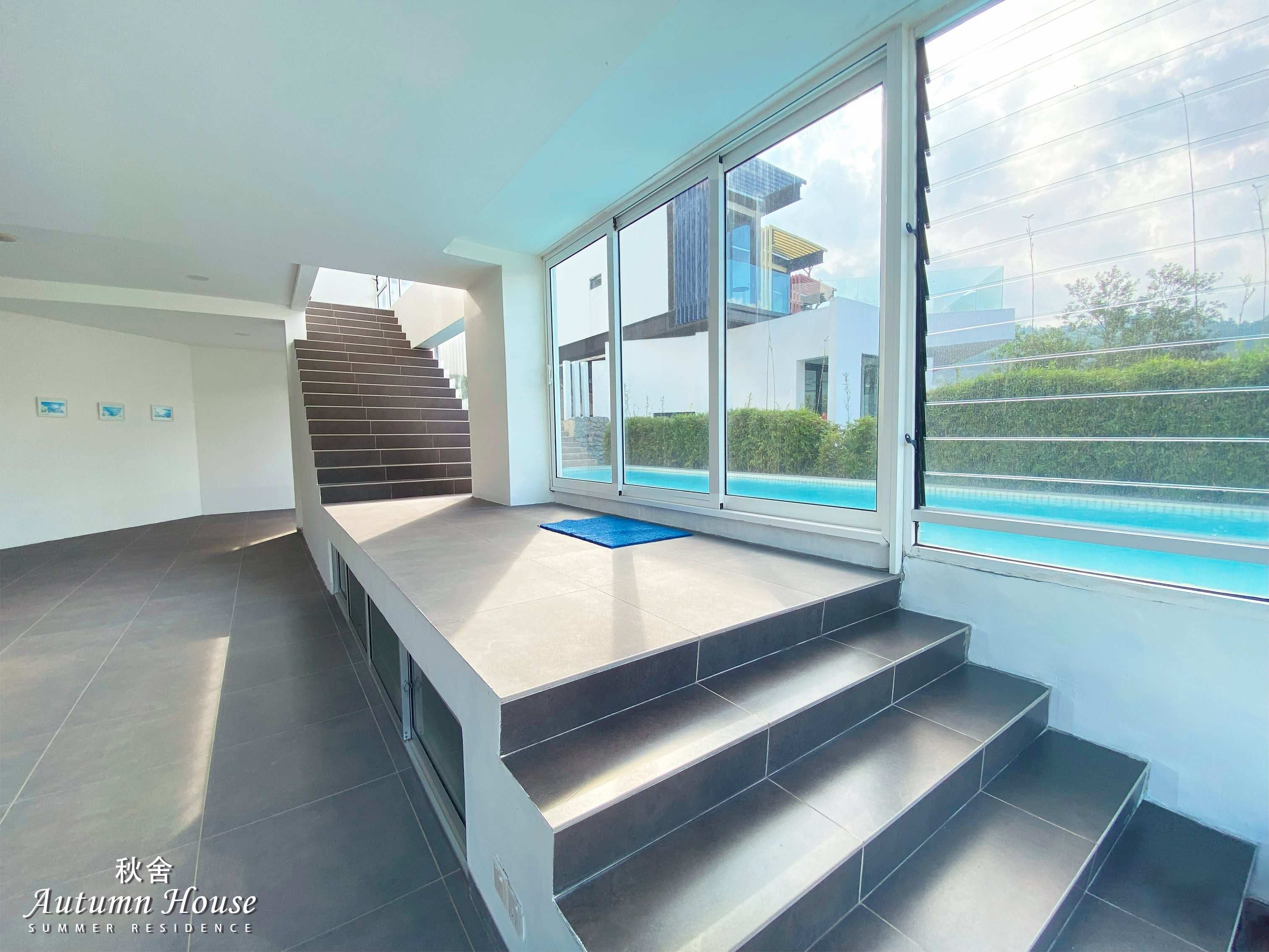 Lower-ground landing where the glass sliding doors open straight onto the pool.