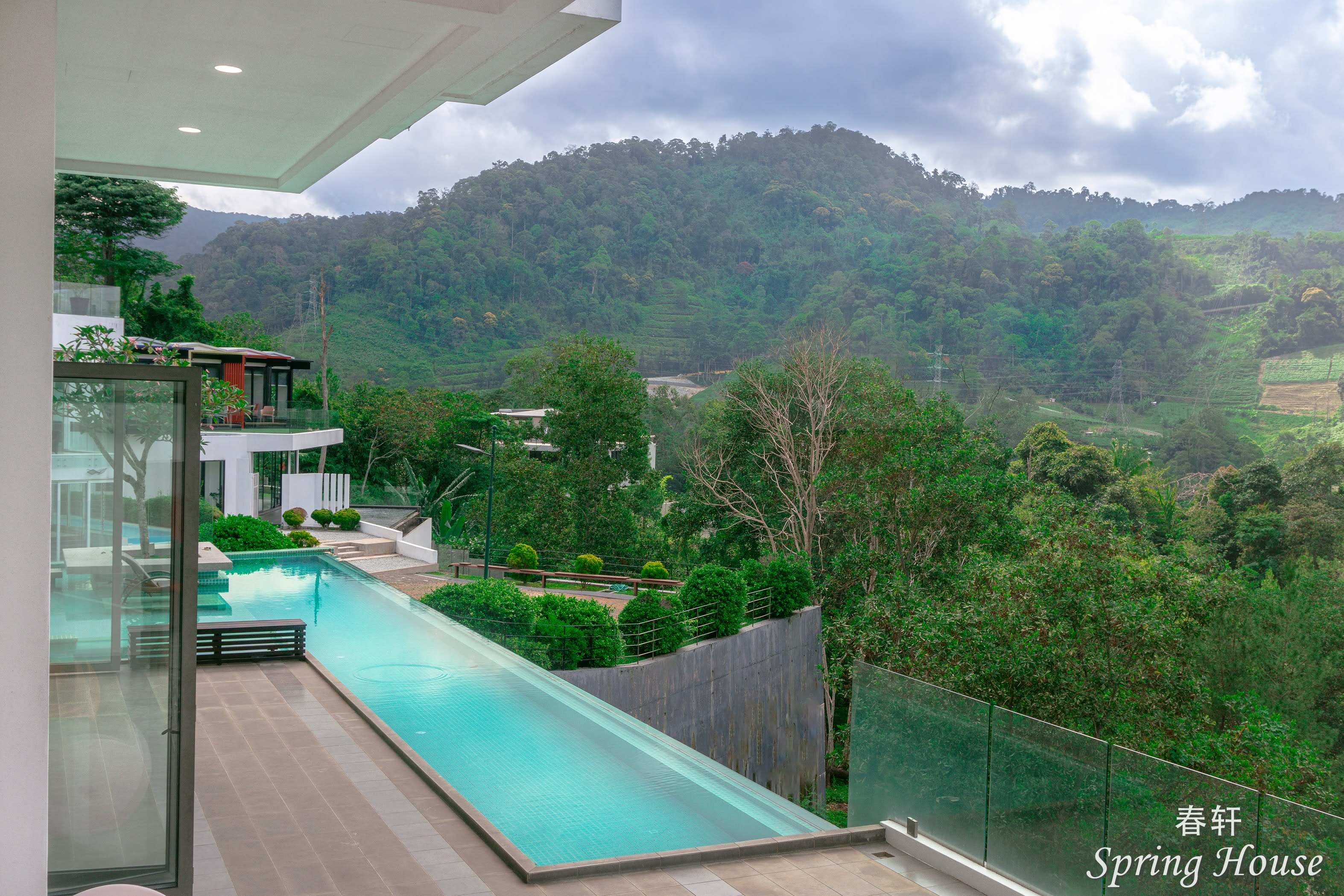 The long lap-pool section beside the terrace, with the opposite villa wing and mountains in view.