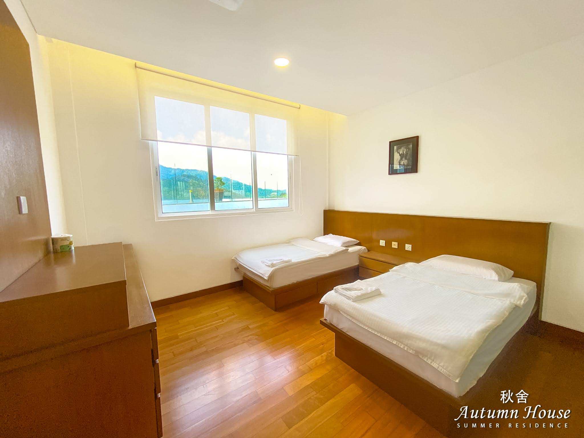 Twin room with two single beds and a window over the hills, a single framed print on the wall.