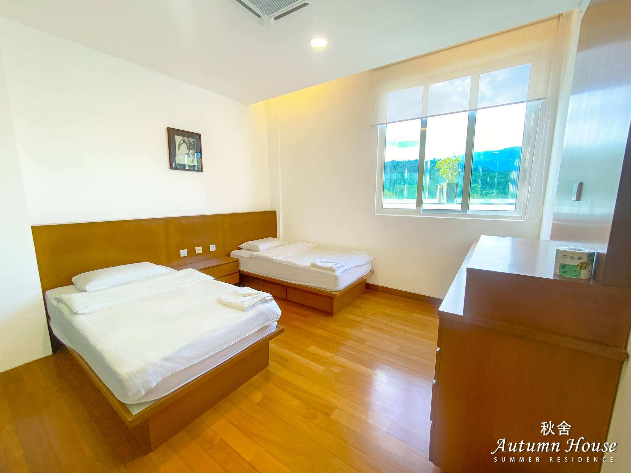 Twin room with a dark wood dresser and mirror beside the mountain-view window.